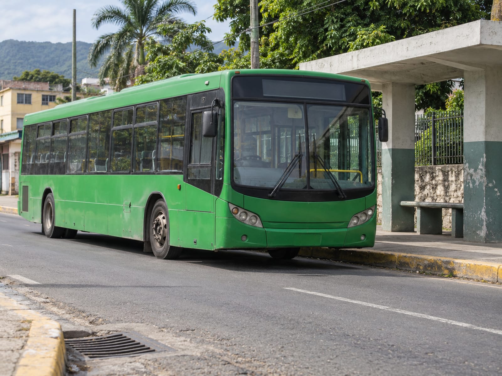 A city bus stopped at a roadside stop in a Caribbean capital