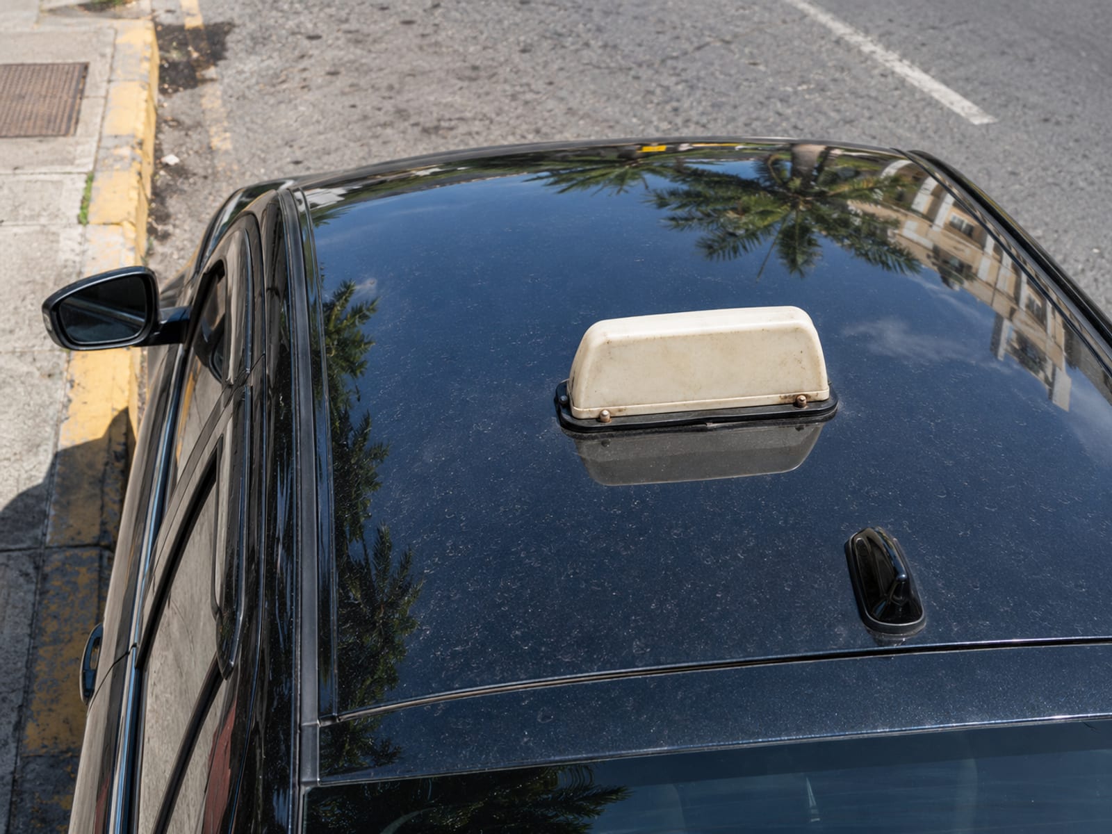 The roof of a parked taxi on a city street