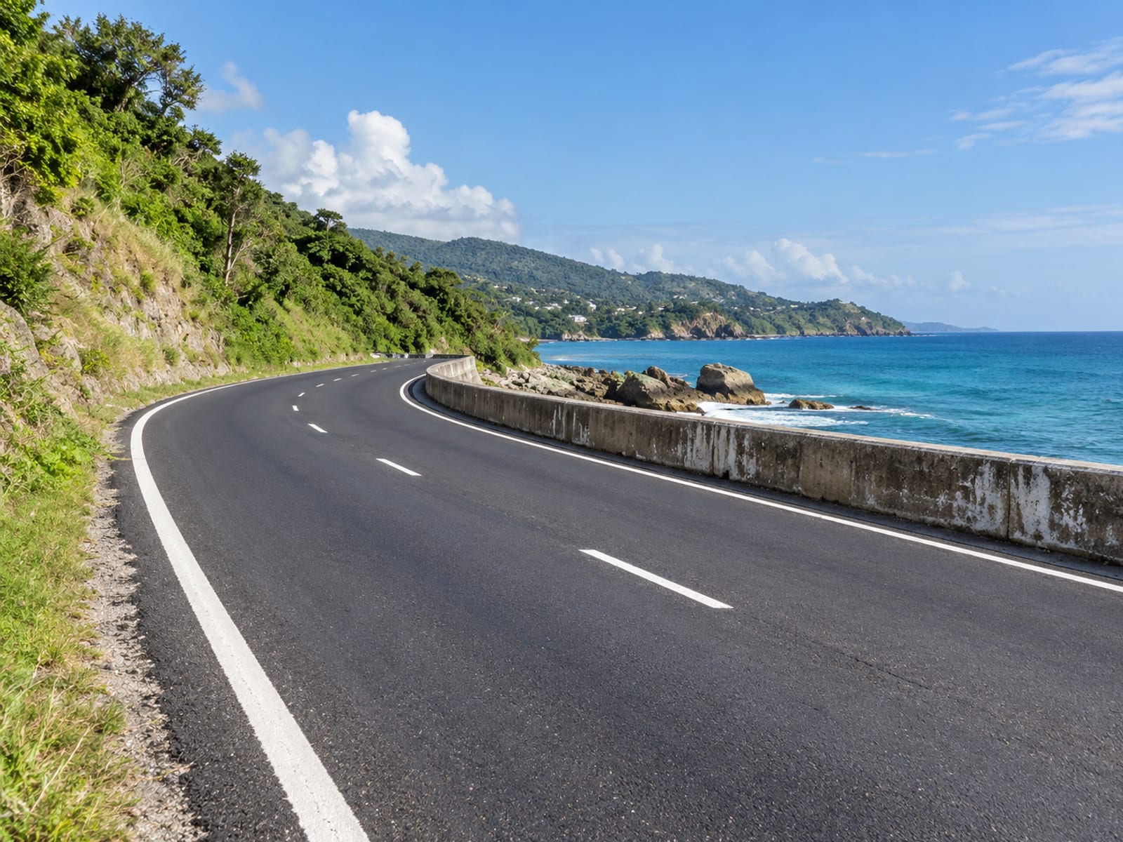 A repaired road curving along the coast beside the sea