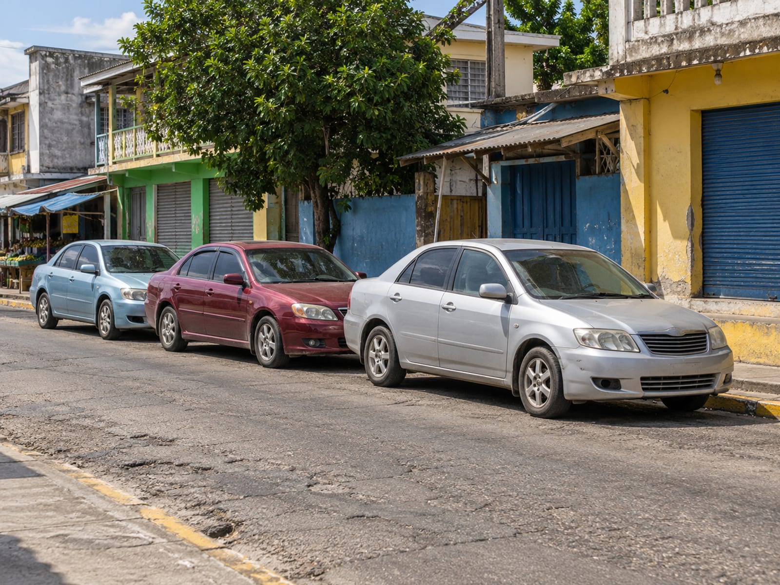 A shared taxi stand beside a market street in a Caribbean town
