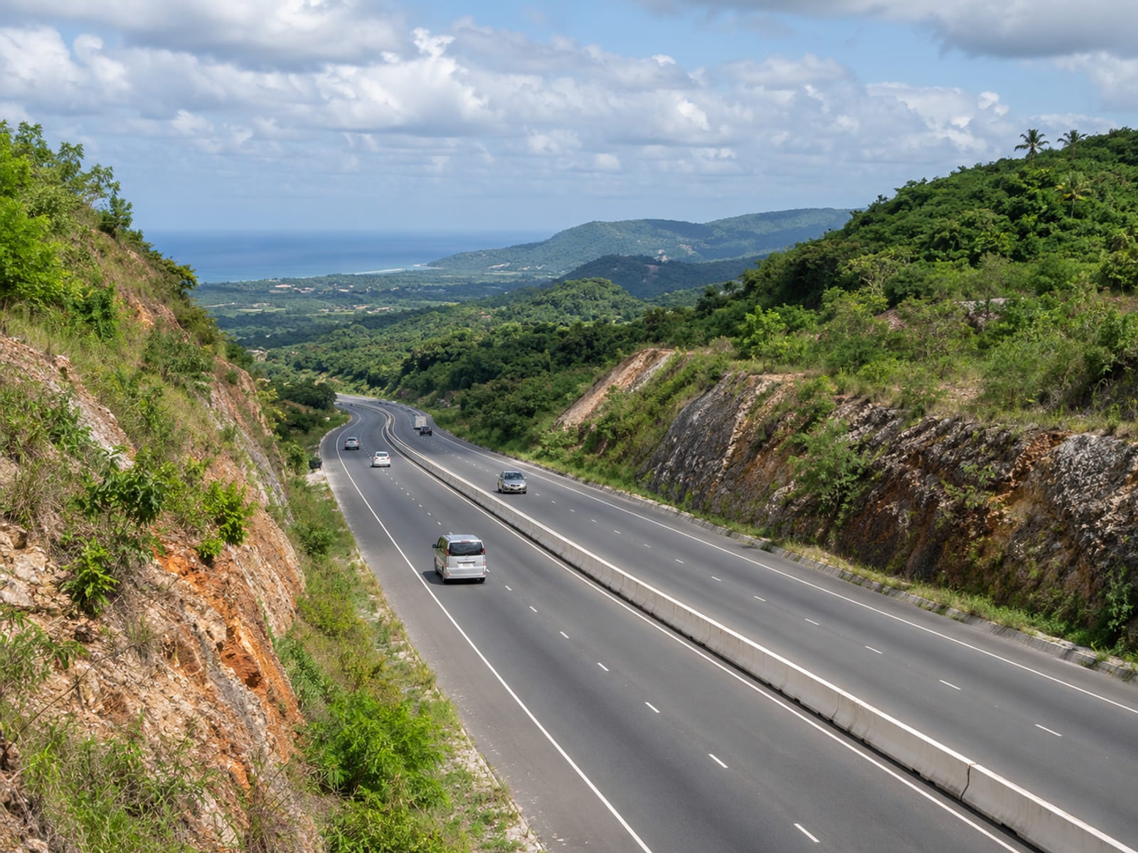 A highway running between green hills towards the north coast