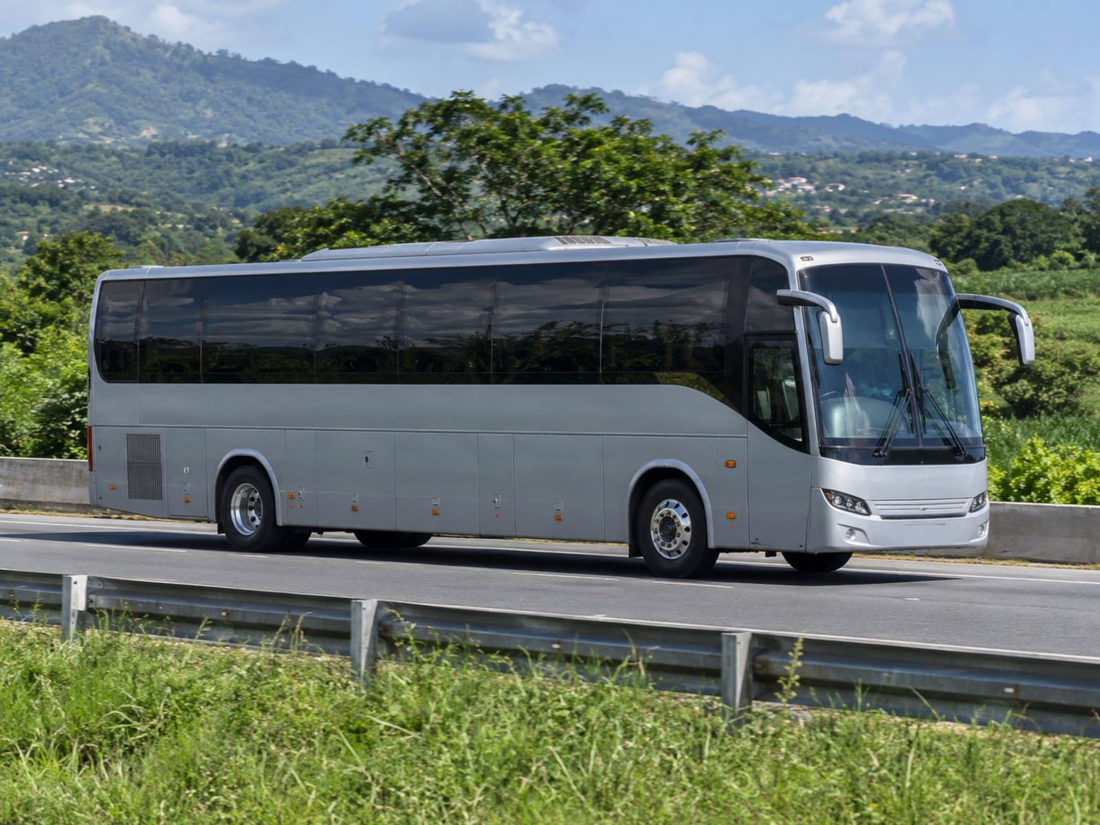 A premium coach driving along a highway through green countryside