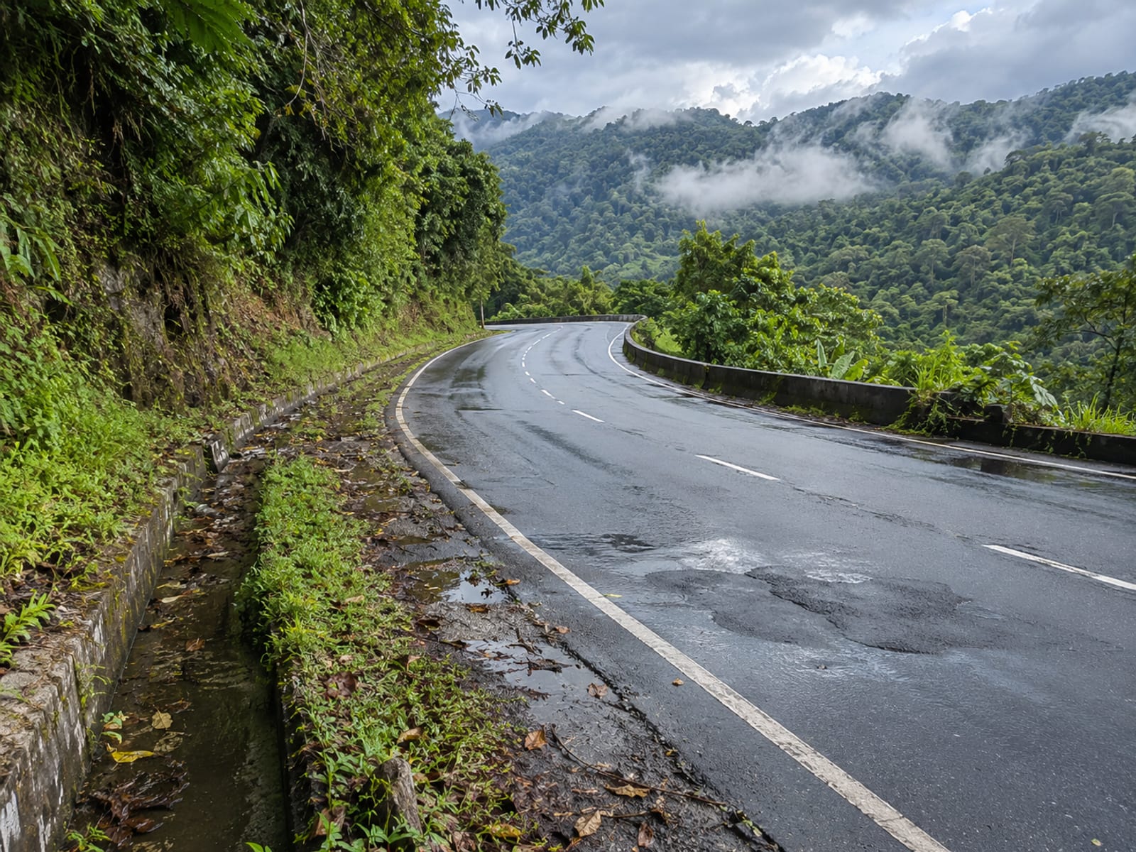 A two-lane highway climbing through green hills in central Jamaica