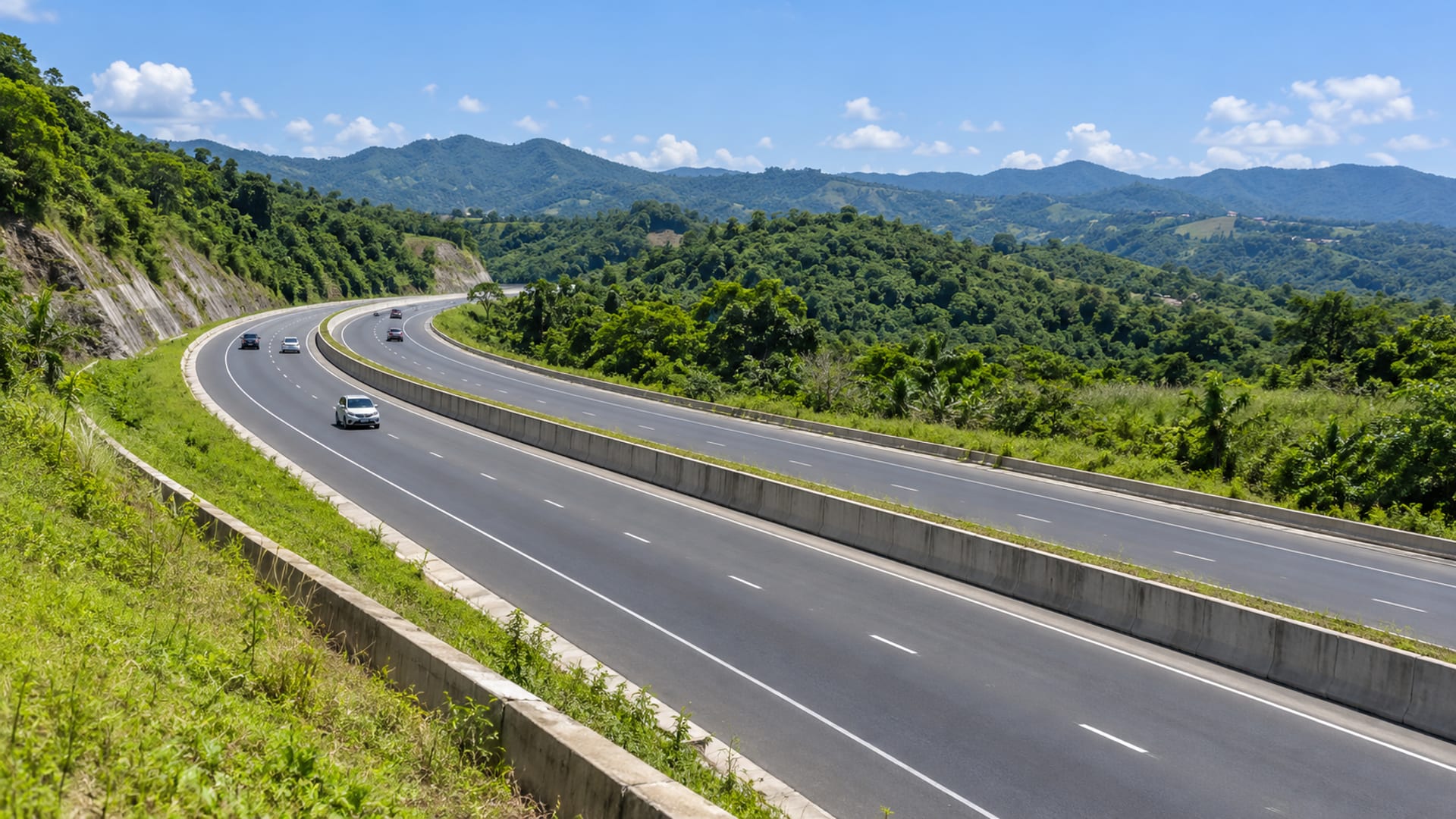 A modern toll highway sweeping through green hills toward the north coast of Jamaica