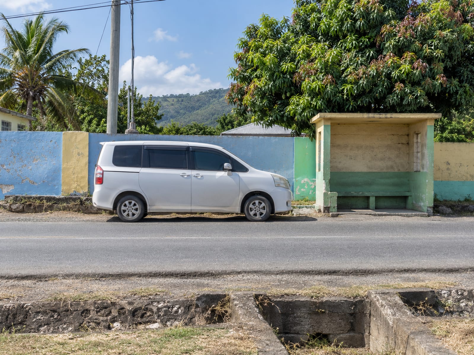 A route taxi waiting at a roadside stop in a small town