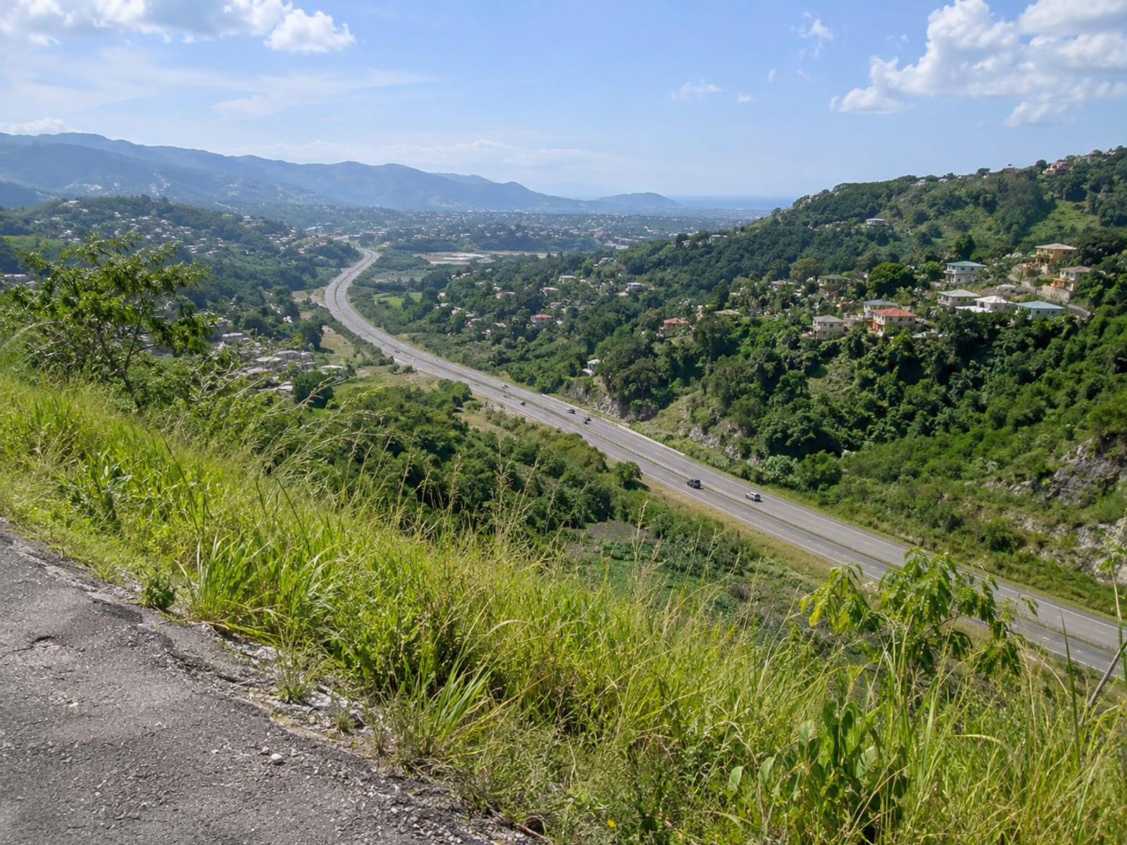 A highway crossing hilly countryside between two Jamaican towns