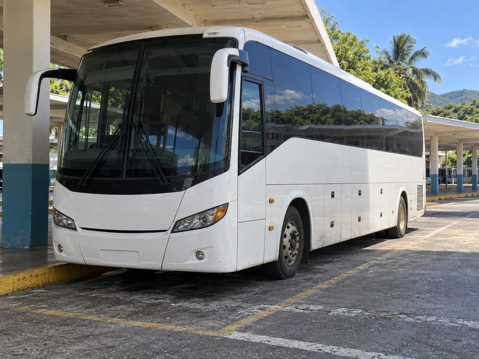 A long-distance coach waiting at a terminal bay in daylight