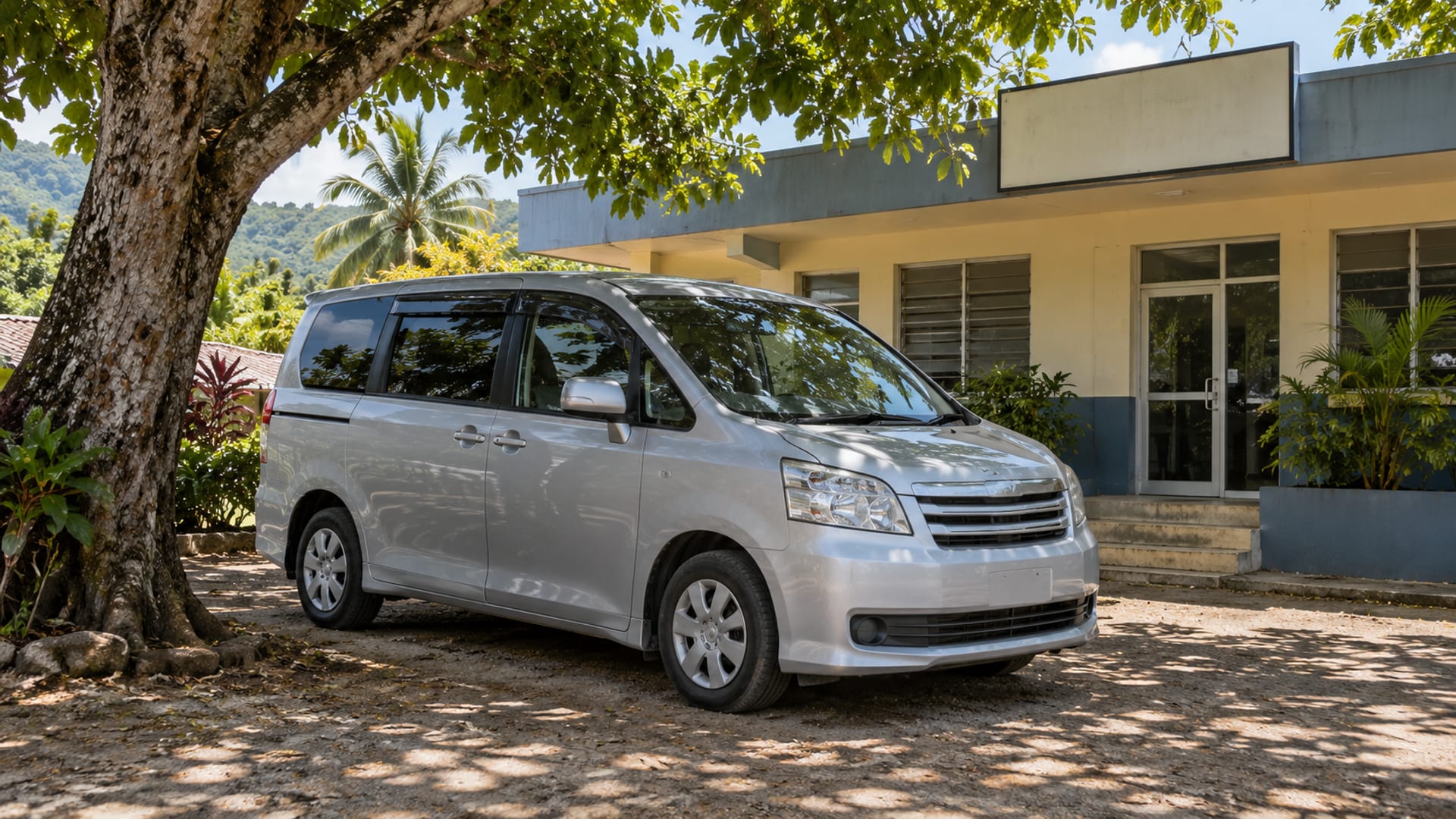 A clean minivan parked in the shade outside a small office