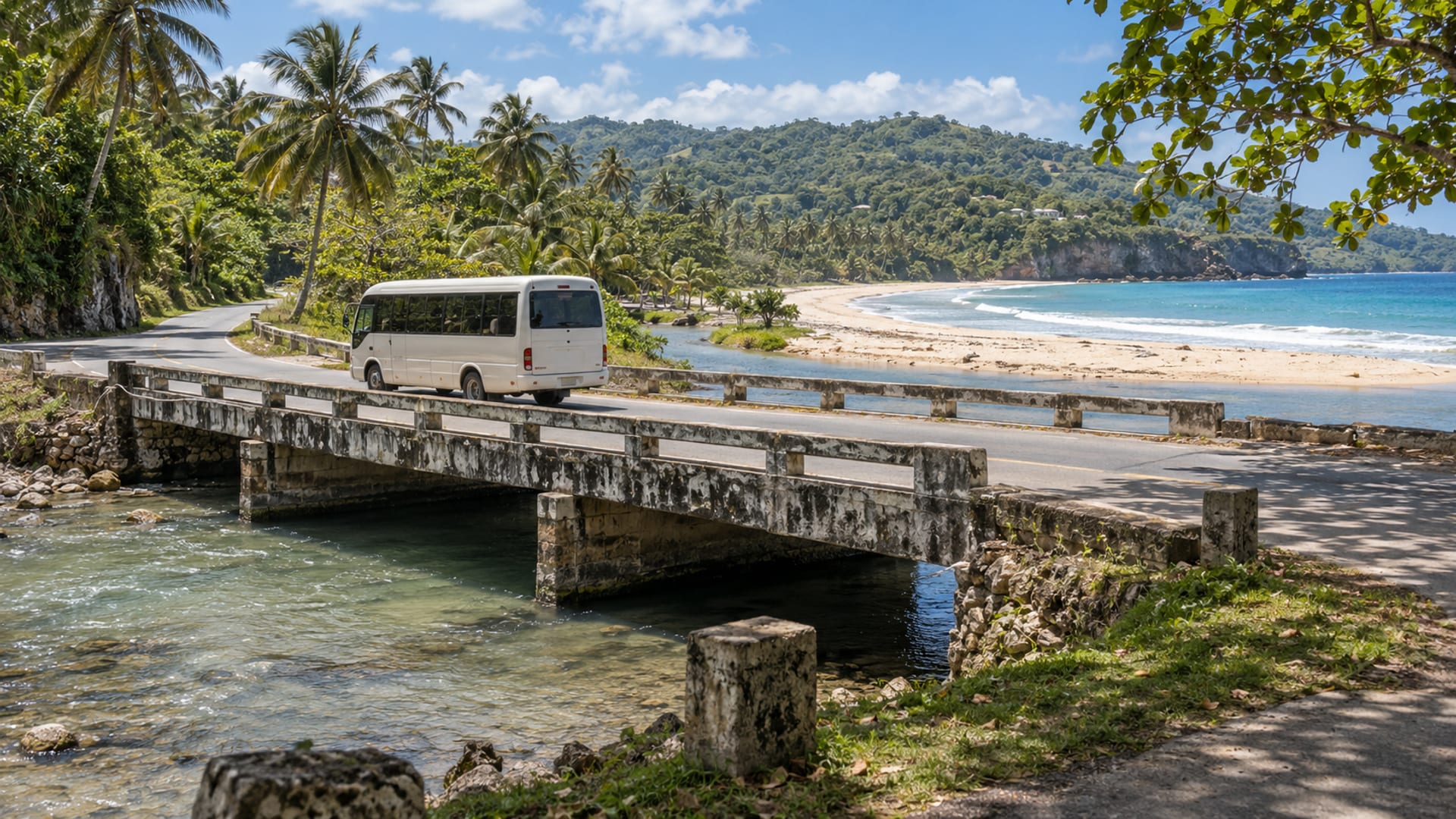 A coast road crossing a low bridge by a river mouth and beach